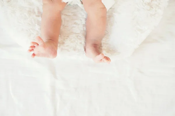 Νεογέννητο μωρό πόδια σε λευκό κρεβάτι. — Φωτογραφία Αρχείου