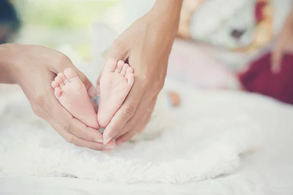 Newbron Baby nohy v rukou matka. — Stock fotografie