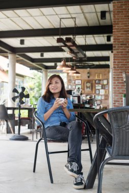 Kafede bir fincan kahve içen güzel genç bir kadın.. 