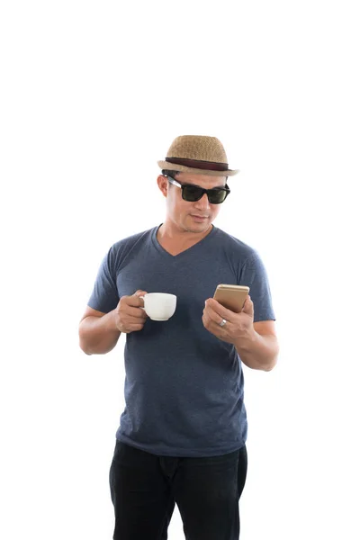 Unga hipster mannen tittar på sin smarta telefon och kaffe i handen — Stockfoto