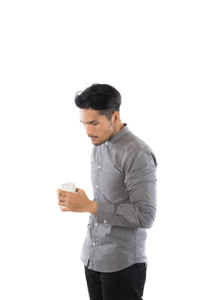 Guapo joven hipster hombre sosteniendo taza de café de pie con isol —  Fotos de Stock