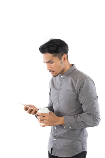 Unga hipster mannen tittar på sin smarta telefon medan kaffekopp i — Stockfoto