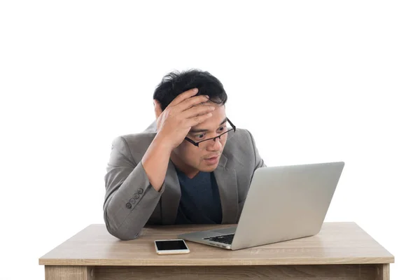 Стресовий бізнесмен працює з ноутбуком, сидячи за столом ізольовано — стокове фото