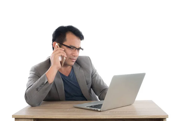 Empresário estressado falando sobre trabalho por telefone com laptop sentado — Fotografia de Stock