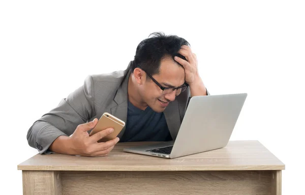 Стресовий бізнесмен працює з ноутбуком, сидячи за столом ізольовано — стокове фото