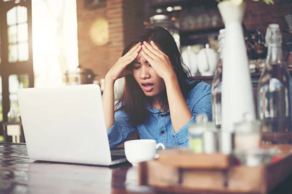 Jovem mulher sentada em um café com seu laptop, estressante para wor — Fotografia de Stock