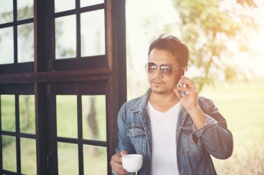 Bir fincan kahve ve kahve dükkanı yürümek tutan hipster adam,