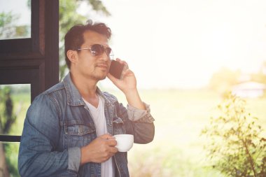 Bir fincan kahve ve kahve dükkanı yürümek tutan hipster adam,