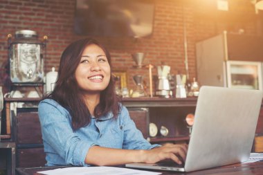 Kafede, dizüstü bilgisayar kullanan genç hipster kadın baktı uzakta bir
