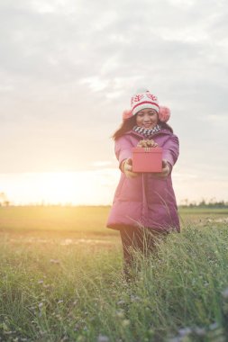 Elinde hediye ile mutlu genç kadın. Noel ve kış conce
