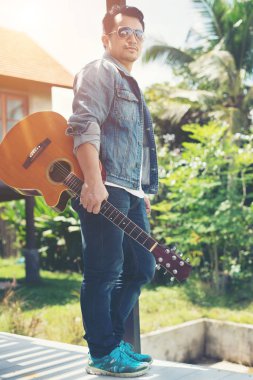 Onun tatil ile rahatlatıcı bir gitar tutan genç müzisyen