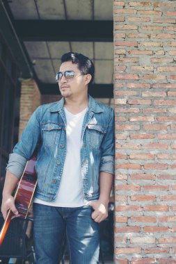 Onun tatil ile rahatlatıcı bir gitar tutan genç müzisyen