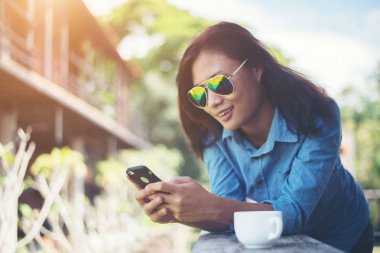 Tipik haber onun telefon ederken ve gülümseme genç hipster kadın.