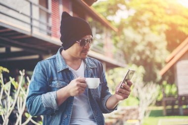 Evde kahve fincanı ile balkon el istirahat hipster adam,