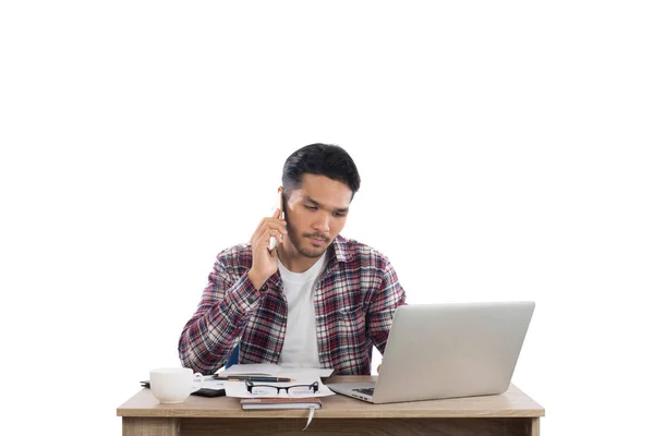 Empresário falando ao telefone enquanto trabalha com laptop no o — Fotografia de Stock