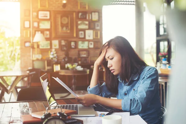 Молода жінка сидить у кафе зі своїм ноутбуком, стрес для турбот — стокове фото