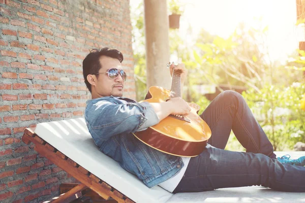Handsome hipster men practice to play guitar while he is enjoyin — Stock Photo, Image