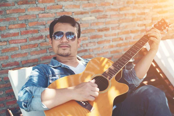 Handsome hipster men practice to play guitar while he is enjoyin — Stock Photo, Image