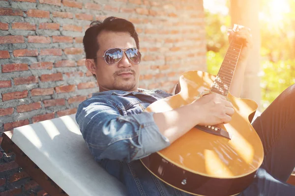 Handsome hipster men practice to play guitar while he is enjoyin — Stock Photo, Image