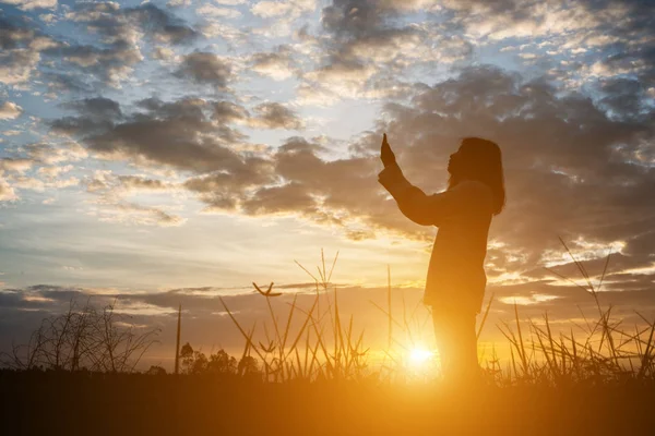 Silhueta de mulheres rezar durante o pôr do sol . — Fotografia de Stock