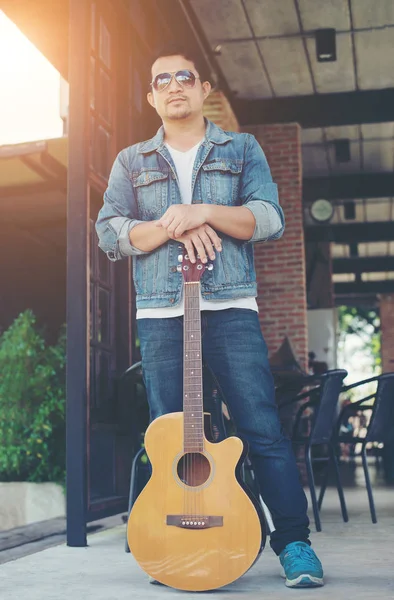 Onun tatil ile rahatlatıcı bir gitar tutan genç müzisyen