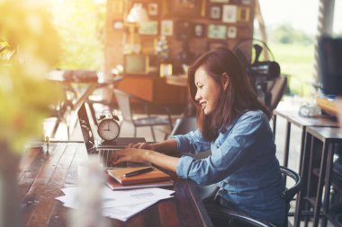 Kahve yudumlarken kafede dizüstü bilgisayar kullanan güzel hipster kadın