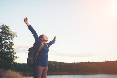 Kayanın üzerinde duran ve günbatımı üzerinde zevk genç uzun yürüyüşe çıkan kimse kadın 