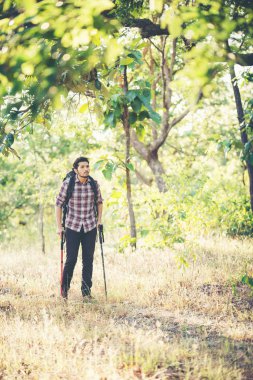 Vaca yürüyüşlere sırasında kırsal yolda yürüyen genç hipster adam