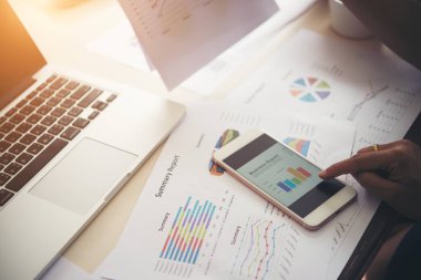 Telefon, hisse senedi grafiklerinde Office ile işadamı el.