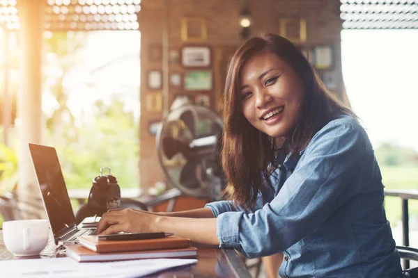Kahve yudumlarken kafede dizüstü bilgisayar kullanan güzel hipster kadın