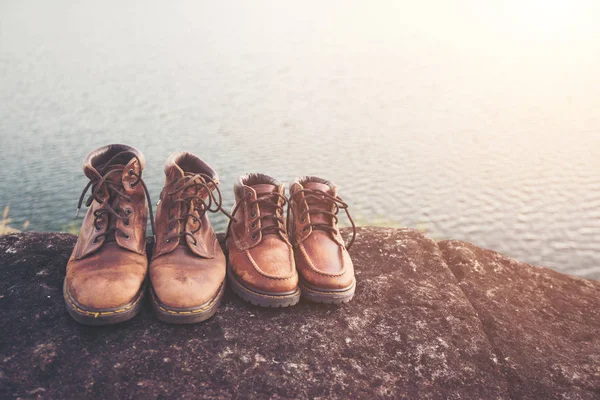 Pareja botas de senderismo en roca con fondo lago naturaleza . — Foto de Stock