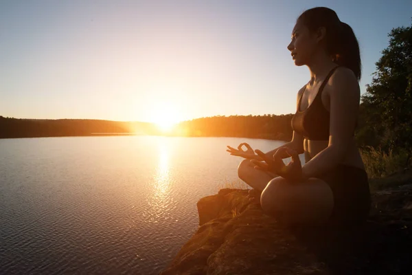 Joven mujer sana está practicando yoga en el lago de montaña durante s —  Fotos de Stock