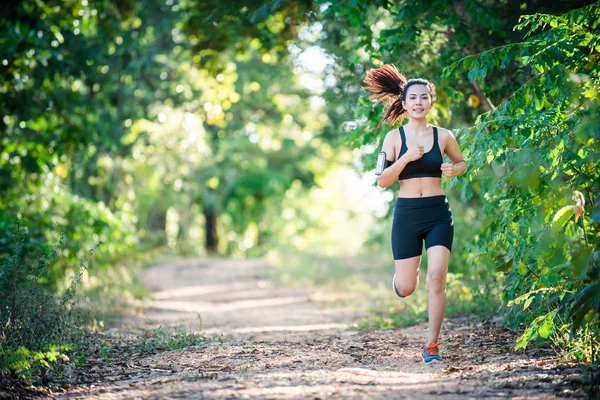 Young fitness woman running on a rural road. Sport woman running