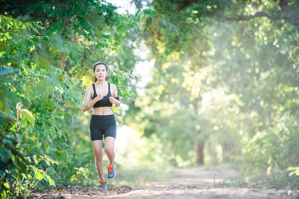 Young fitness woman running on a rural road. Sport woman running