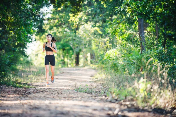 Junge Fitness-Frau läuft auf einer Landstraße. Sportlerin läuft — Stockfoto