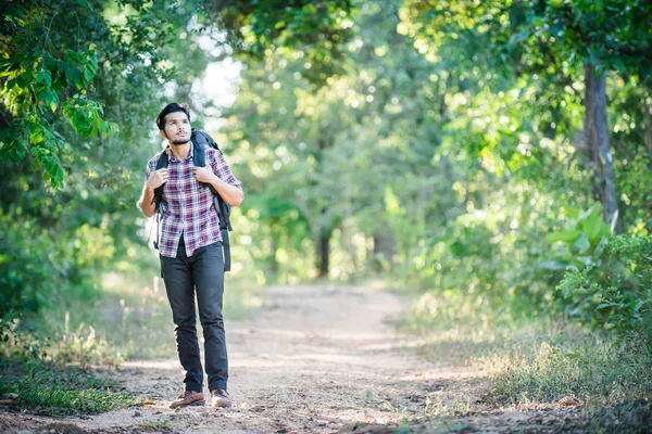 Junger Hipster-Mann läuft auf Landstraße bei Wanderungen im Urlaub — Stockfoto