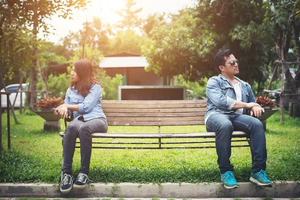 Nespokojený mladý pár sedí na lavičce v parku, pár lifesty — Stock fotografie