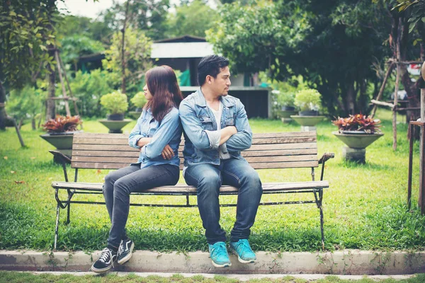 Descontente jovem casal sentado no banco no parque, Couple lifesty — Fotografia de Stock