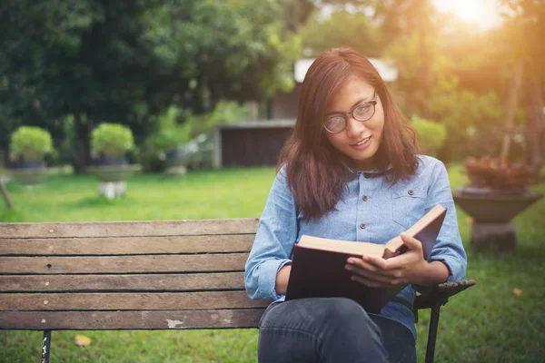 Hipster chica encantadora relajarse en el parque mientras lee el libro, Enjo — Foto de Stock