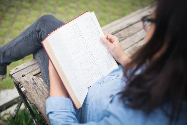 Hipster chica encantadora relajarse en el parque mientras lee el libro, Enjo — Foto de Stock