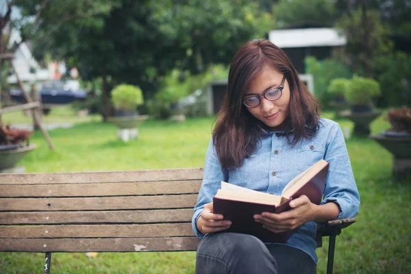 Hipster charmante dame ontspannen in het park terwijl lees boek, Enjo — Stockfoto