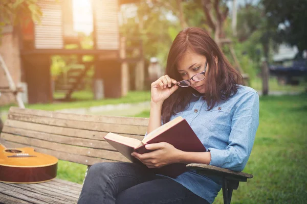 Hipster encantadora menina relaxante no parque enquanto ler livro, Enjo — Fotografia de Stock