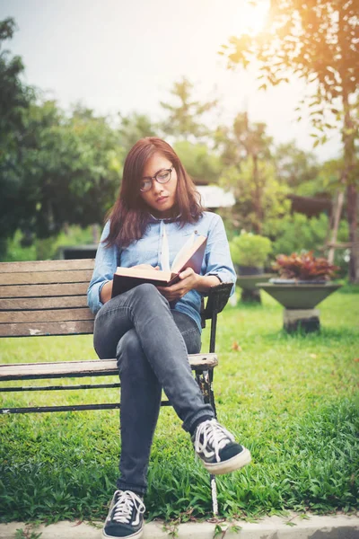 Hipster encantadora menina relaxante no parque enquanto ler livro, Enjo — Fotografia de Stock