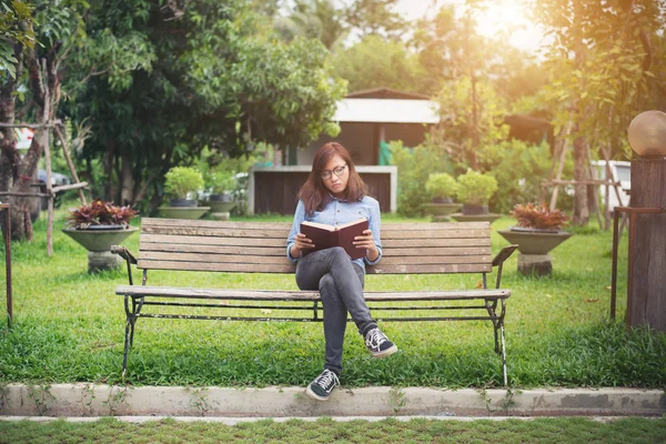 Hipster encantadora menina relaxante no parque enquanto ler livro, Enjo — Fotografia de Stock