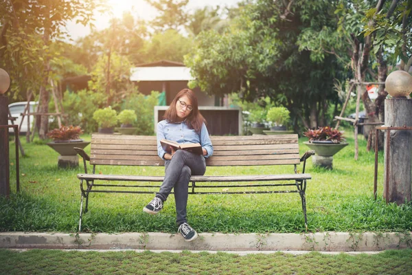 Hipster encantadora menina relaxante no parque enquanto ler livro, Enjo — Fotografia de Stock