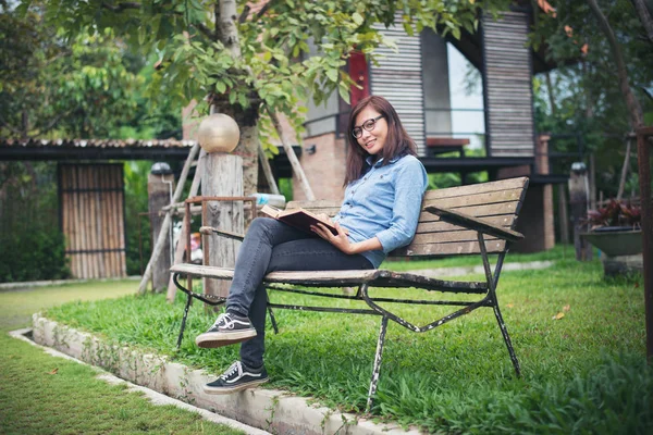 Hipster charmig flicka avkopplande i parken medan Läs boken, Enjo — Stockfoto