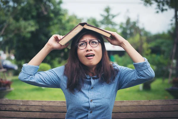 Jonge hipster vrouw dekken haar hoofd met boek, bang voor somethin — Stockfoto