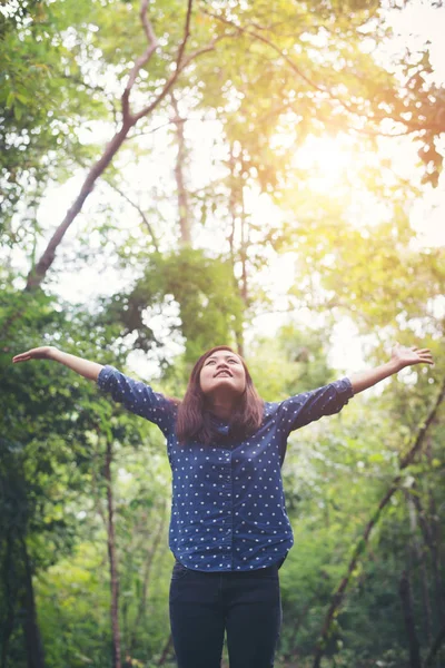 Attraente giovane donna in piedi in una foresta, le mani sparse in giro — Foto Stock
