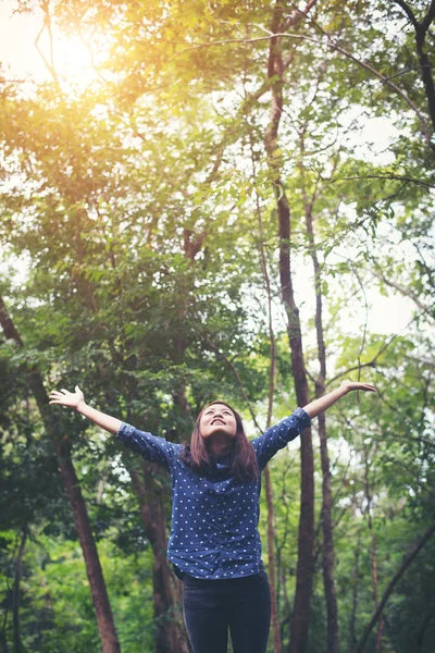 Attraktive junge Frau, die im Wald steht, die Hände ausgebreitet — Stockfoto