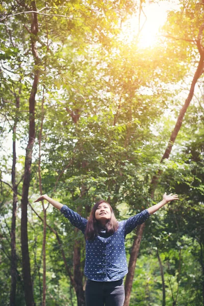 Attractive young woman standing in a forest, hands spread around — Stock Photo, Image